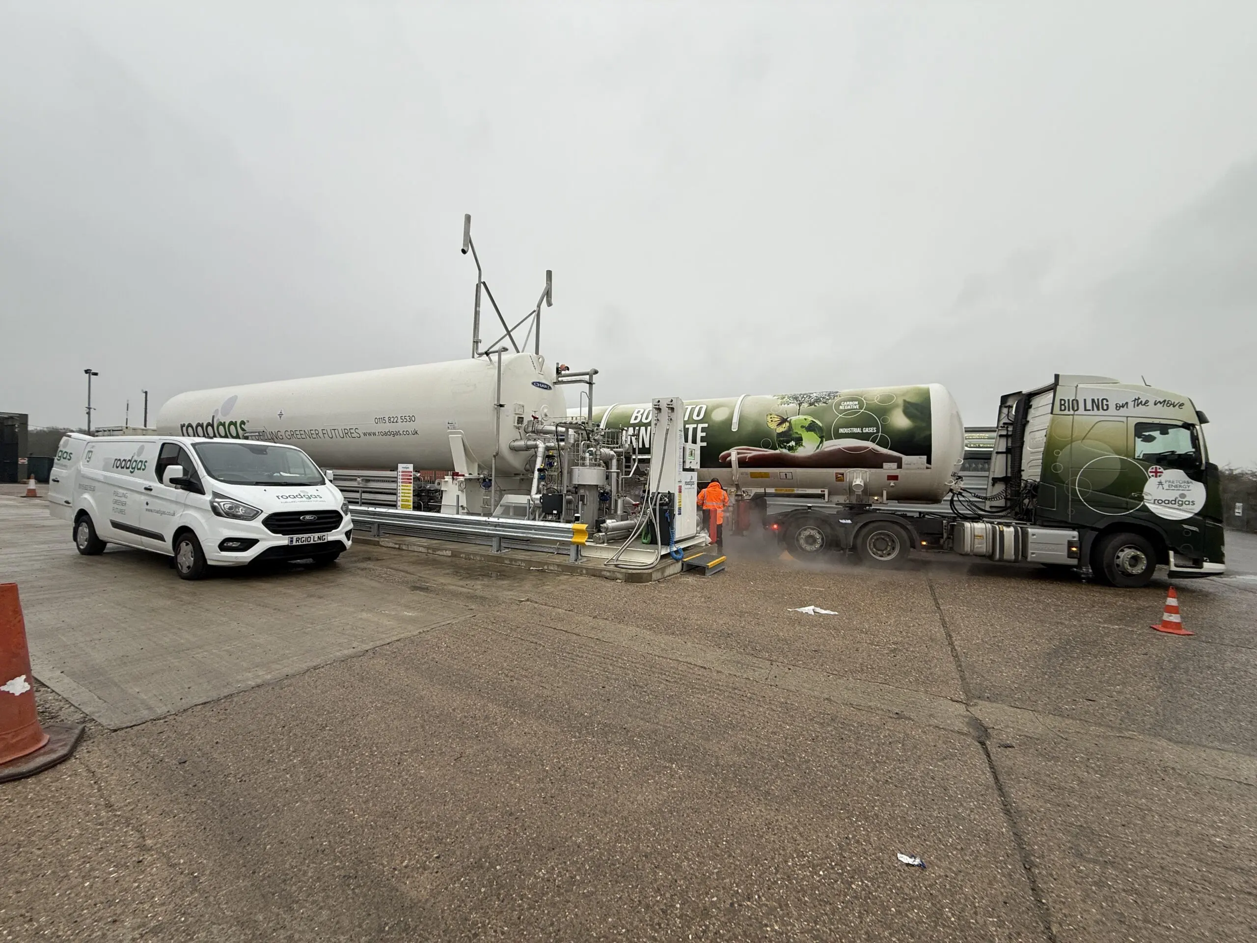 A Roadgas Bio-LNG refuelling station with a gas truck and service vehicle during refuelling, supporting low-carbon transport for UK logistics fleets.