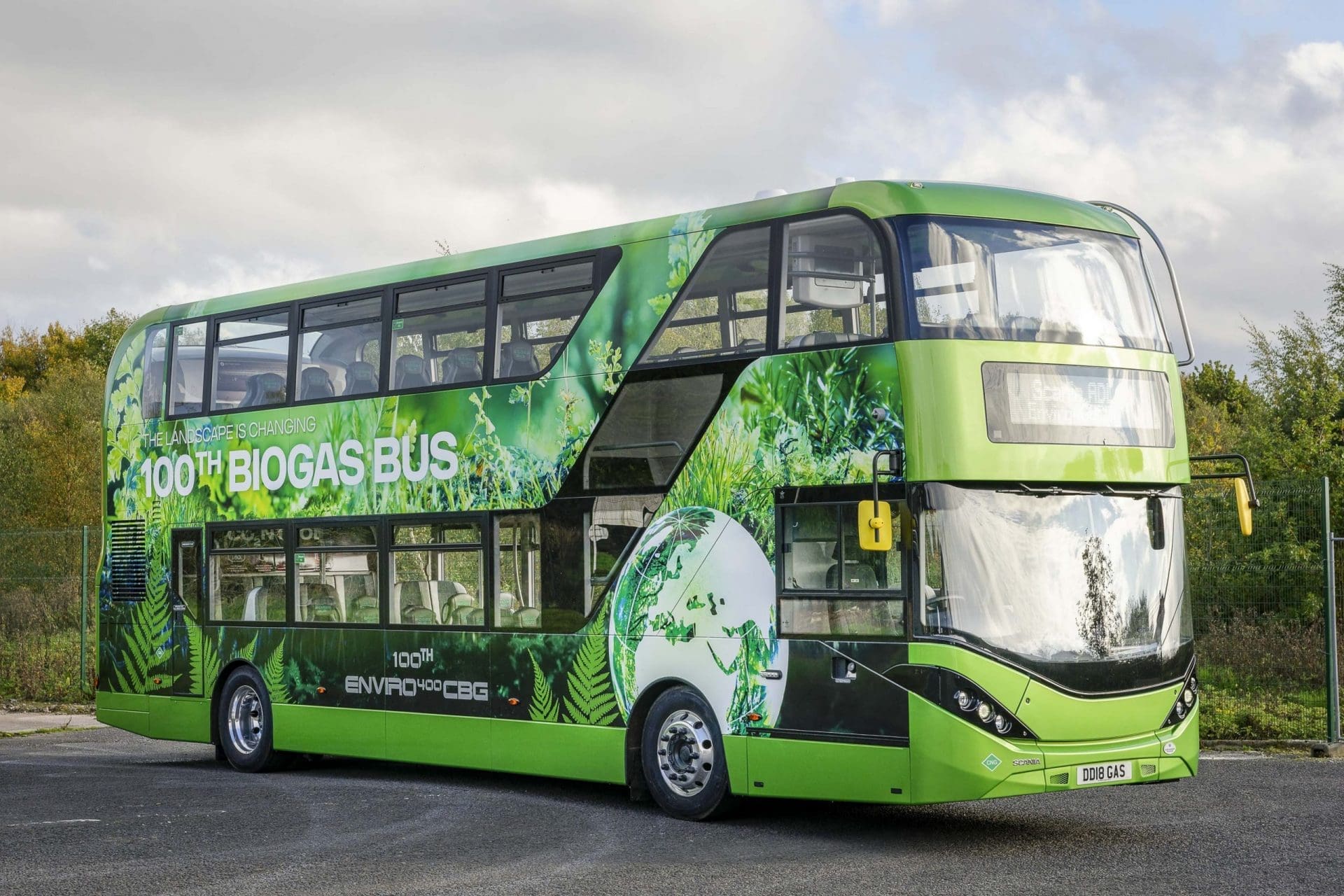 A green double-decker bus featuring '100th Biogas Bus' branding, showcasing renewable gas initiatives in the UK for low-carbon transport.