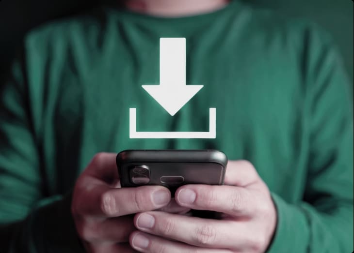Person holding a smartphone with a download icon, representing mobile app usage for fleet management
