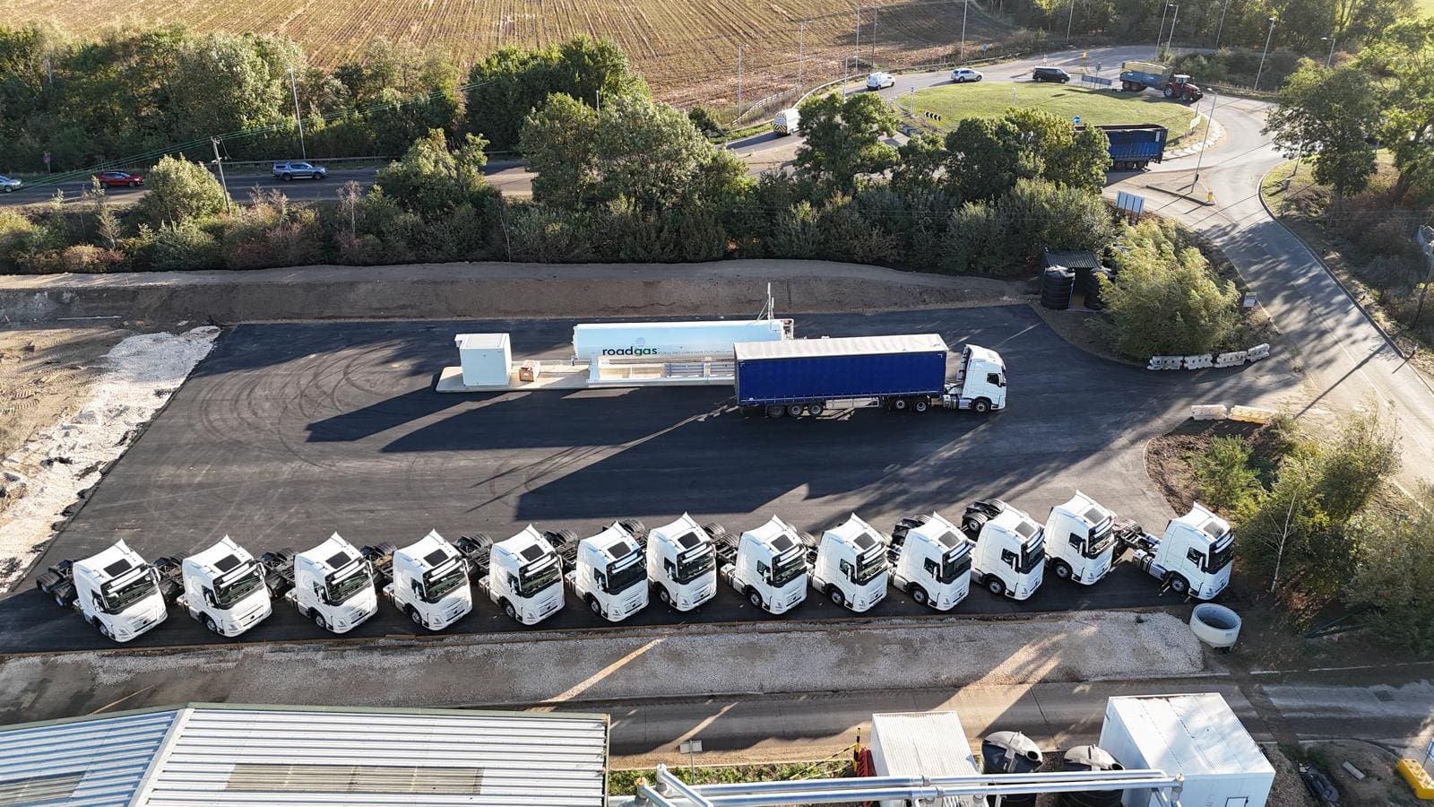 Aerial view of Roadgas Bio-LNG trucks lined up at a refuelling station, showcasing renewable gas infrastructure for UK HGV fleets.