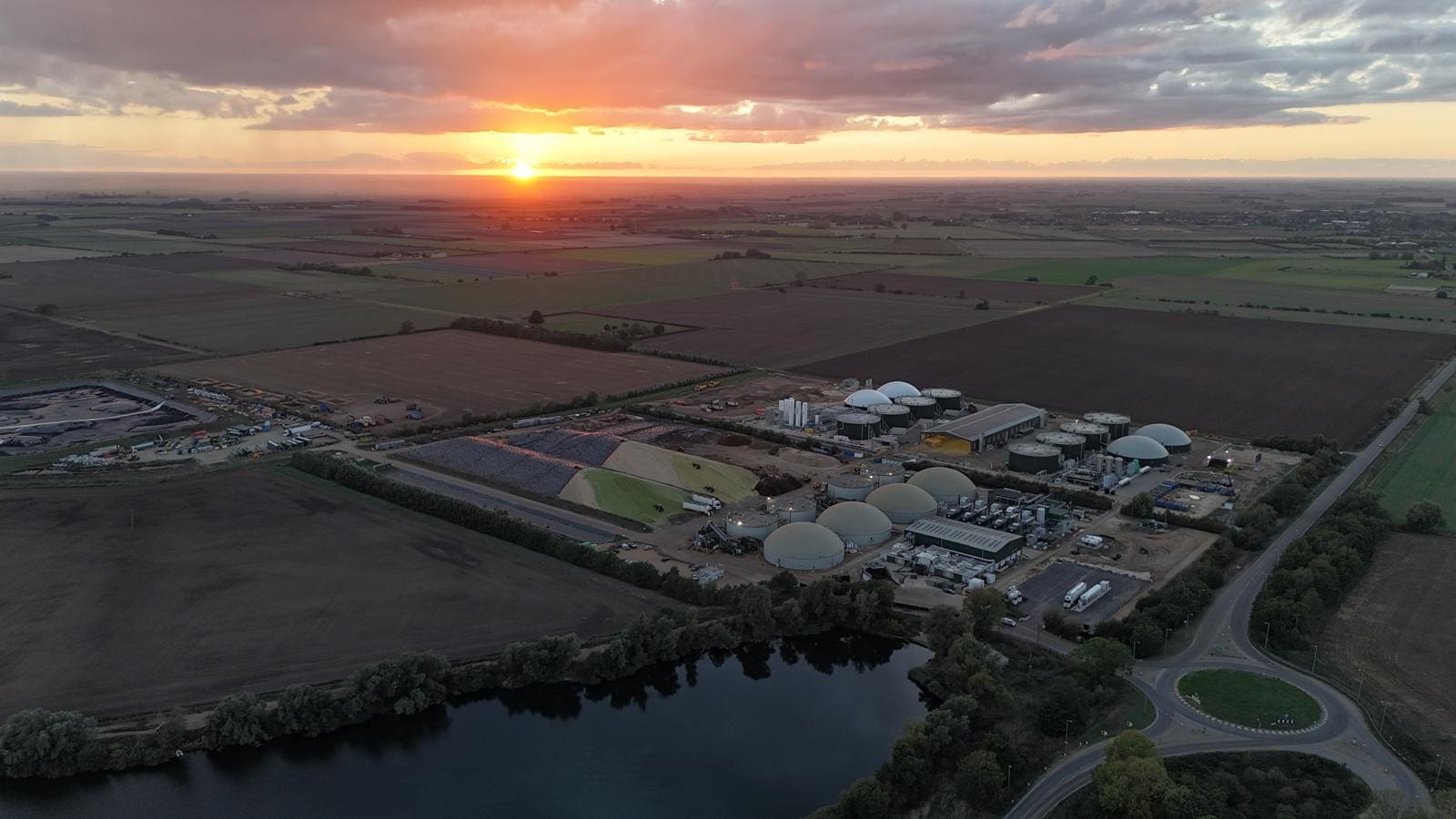 Aerial image showcasing a renewable gas facility with biogas storage domes and surrounding farmland, highlighting infrastructure for Bio-LNG and Bio-CNG refuelling in the UK.