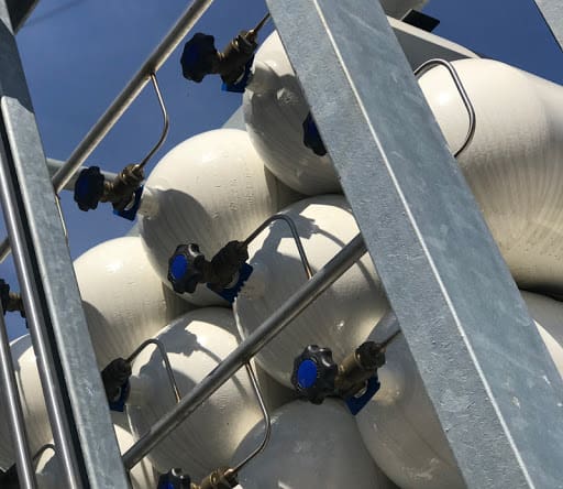 Close-up of renewable gas storage tanks showing valves and piping, essential for Bio-LNG and Bio-CNG refuelling infrastructure.